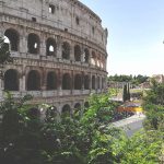 The ancient Colosseum in Rome under a clear sky.