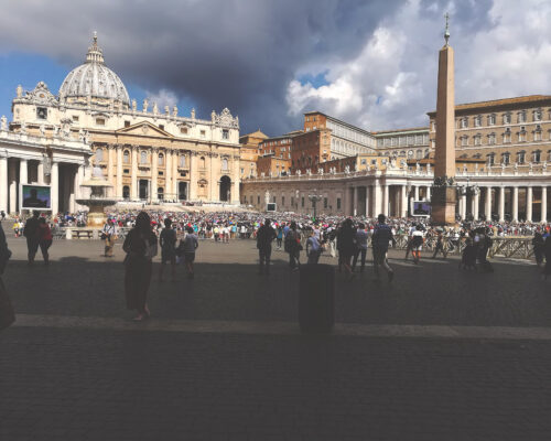 Crowd gathers in St. Peter's Square under dramatic skies. Crowd gathers in St. Peter's Square under dramatic skies.