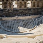 Ancient Roman amphitheater with stone seating and stage area.