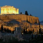 The illuminated Parthenon atop the Acropolis at dusk.