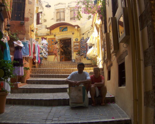 Two people sitting on steps in a narrow, charming street. Two people sitting on steps in a narrow, charming street.