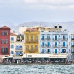 Colorful buildings along a waterfront under a cloudy sky.