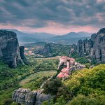 Dramatic cliffs and lush valley under a moody sky.