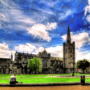 Historic stone building with a tall spire under a vibrant sky.
