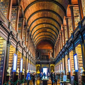 Interior view of a grand library with wooden arches and tall bookshelves.