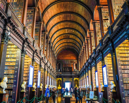 Interior view of a grand library with wooden arches and tall bookshelves. Interior view of a grand library with wooden arches and tall bookshelves.